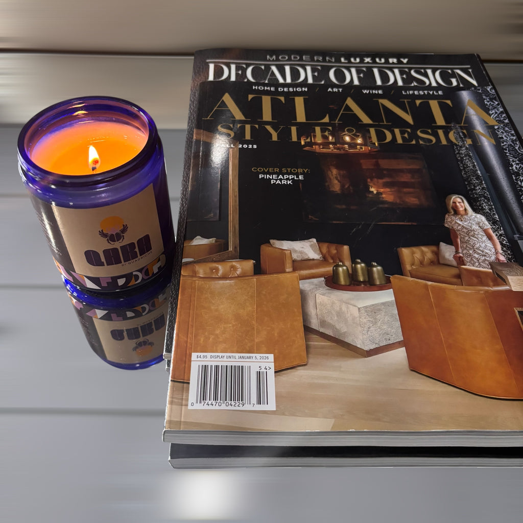 QARA Candle and magazine titled 'Modern Luxury: Decade of Design' on a reflective surface