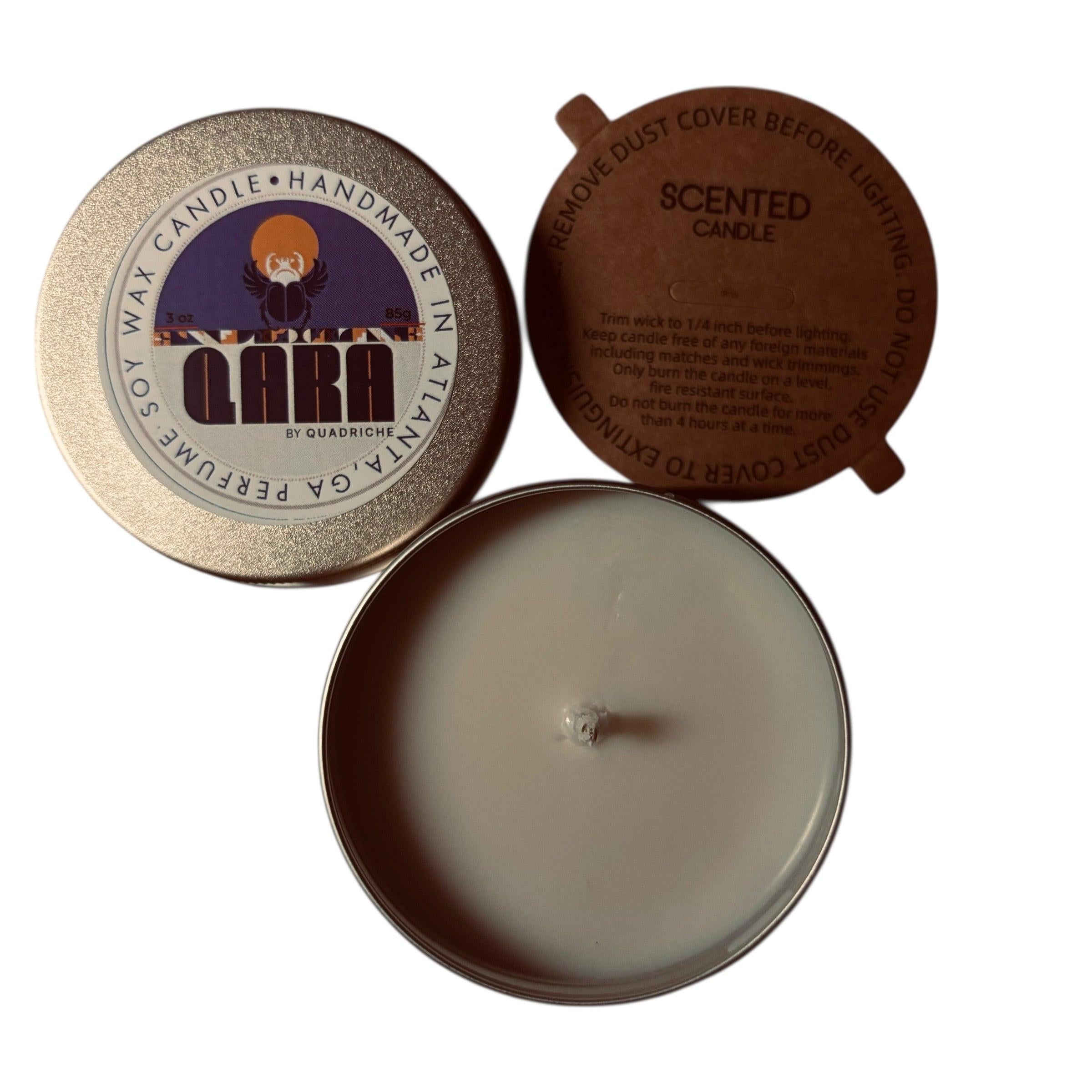 Ember Ink QARA by Quadriche Discovery Travel 3oz Candle in a tin with a label on a concrete surface peppercorn violet pine sage juniper leather fragrance scent