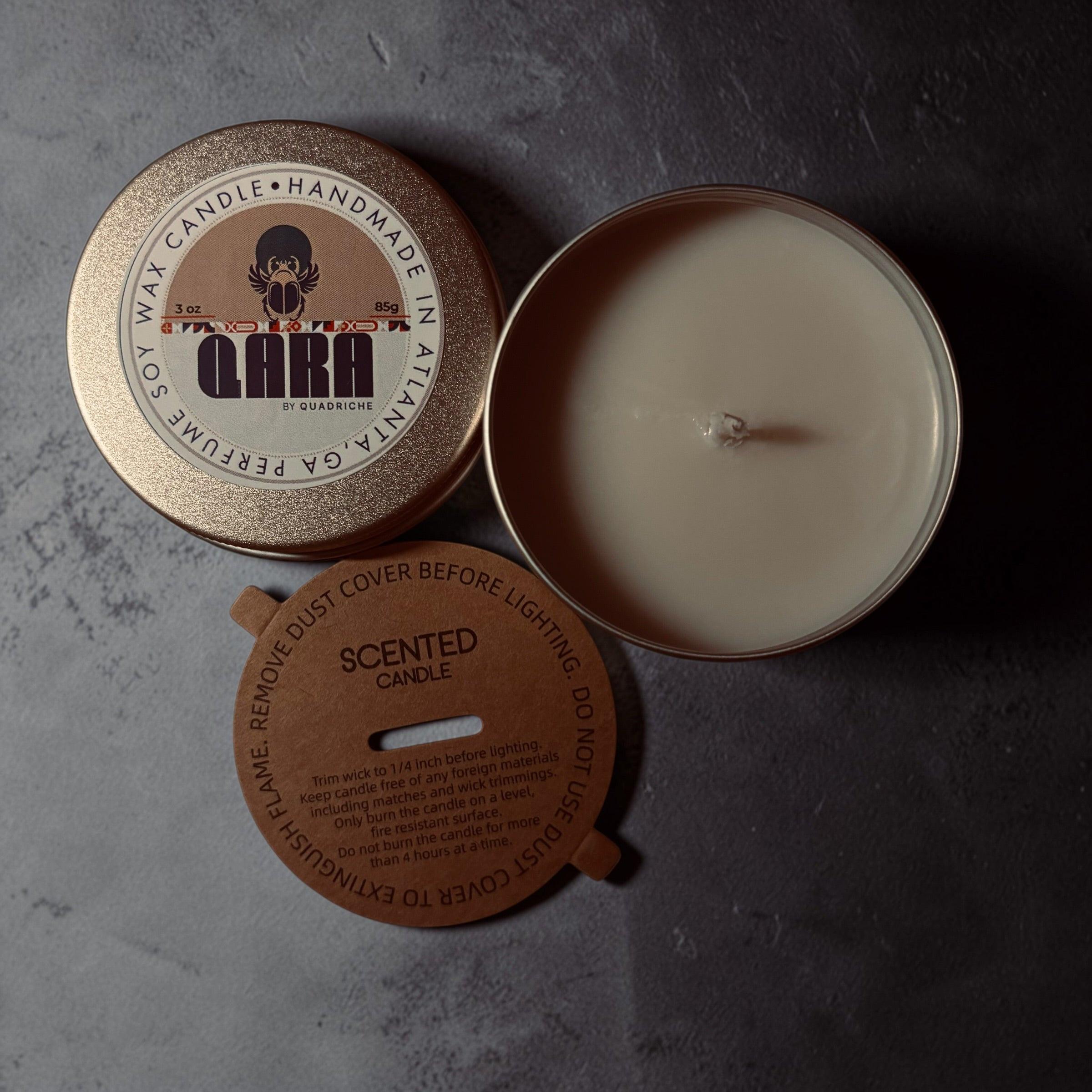 Māori Forest QARA by Quadriche Discovery Travel 3oz Candle in a tin with a label on a white surface orange amber scent 