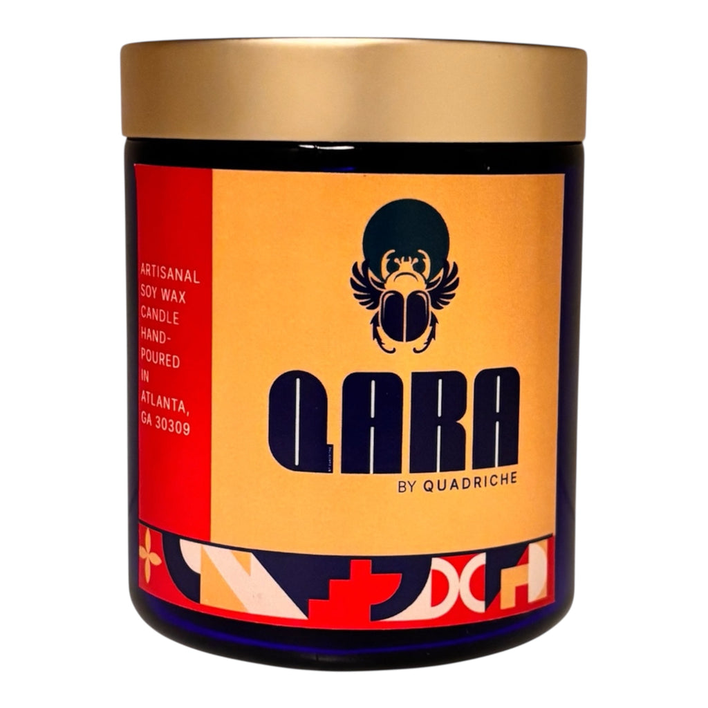 Candle jar with gold lid and colorful label featuring the brand 'QARA by Quadriche'.