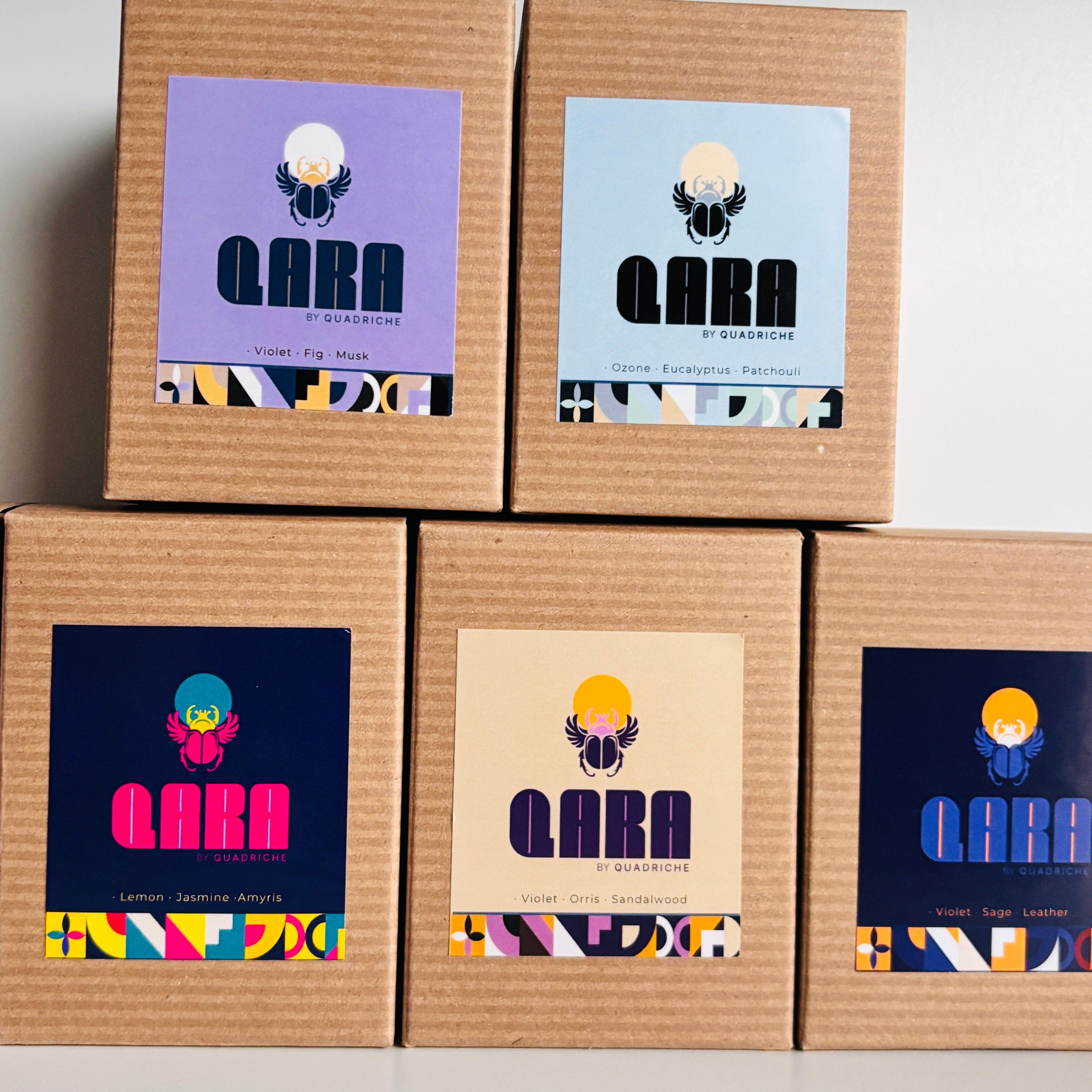 Five cardboard boxes with colorful 'QARA by Quadriche' labels on a white background