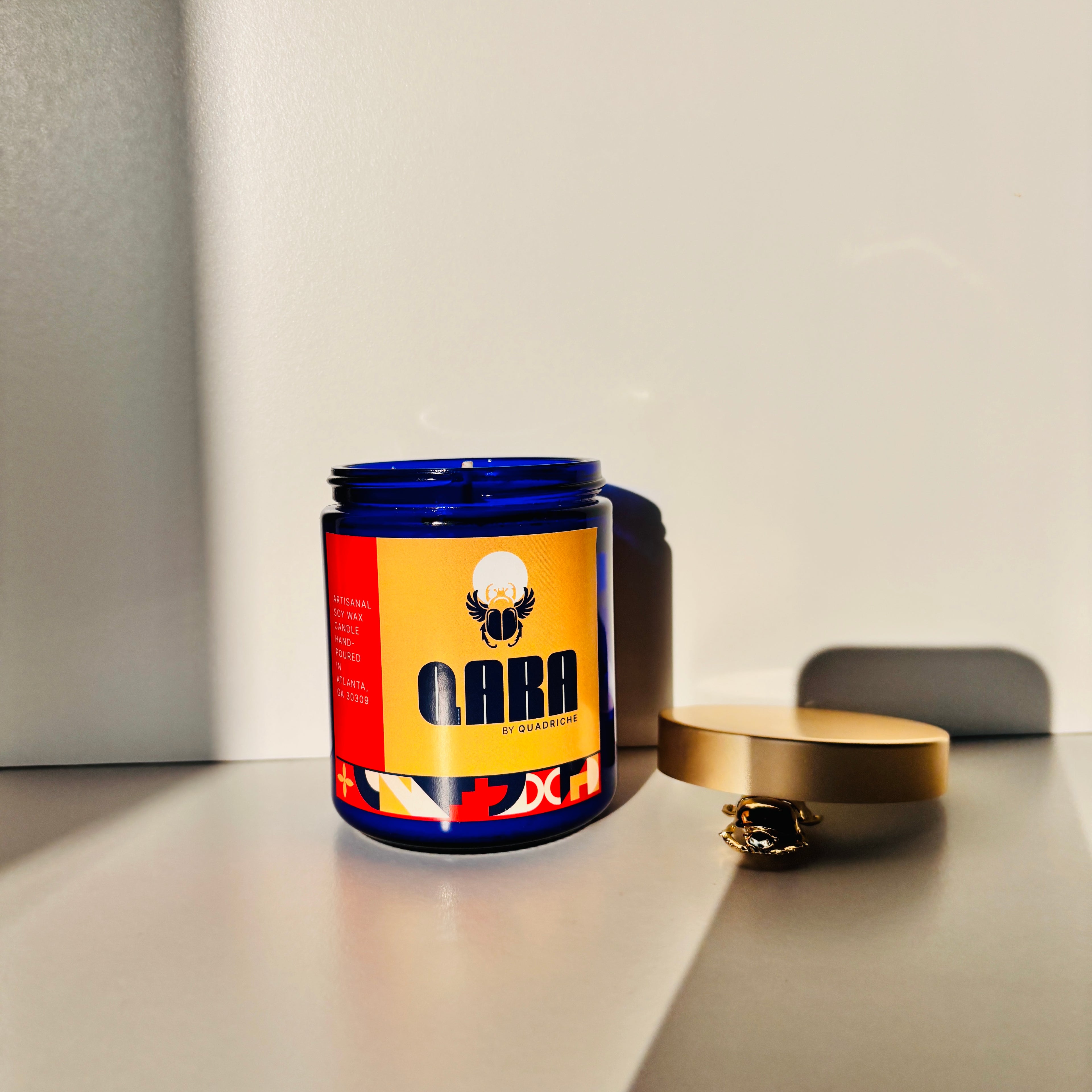 Candle jar with a colorful label on a neutral background