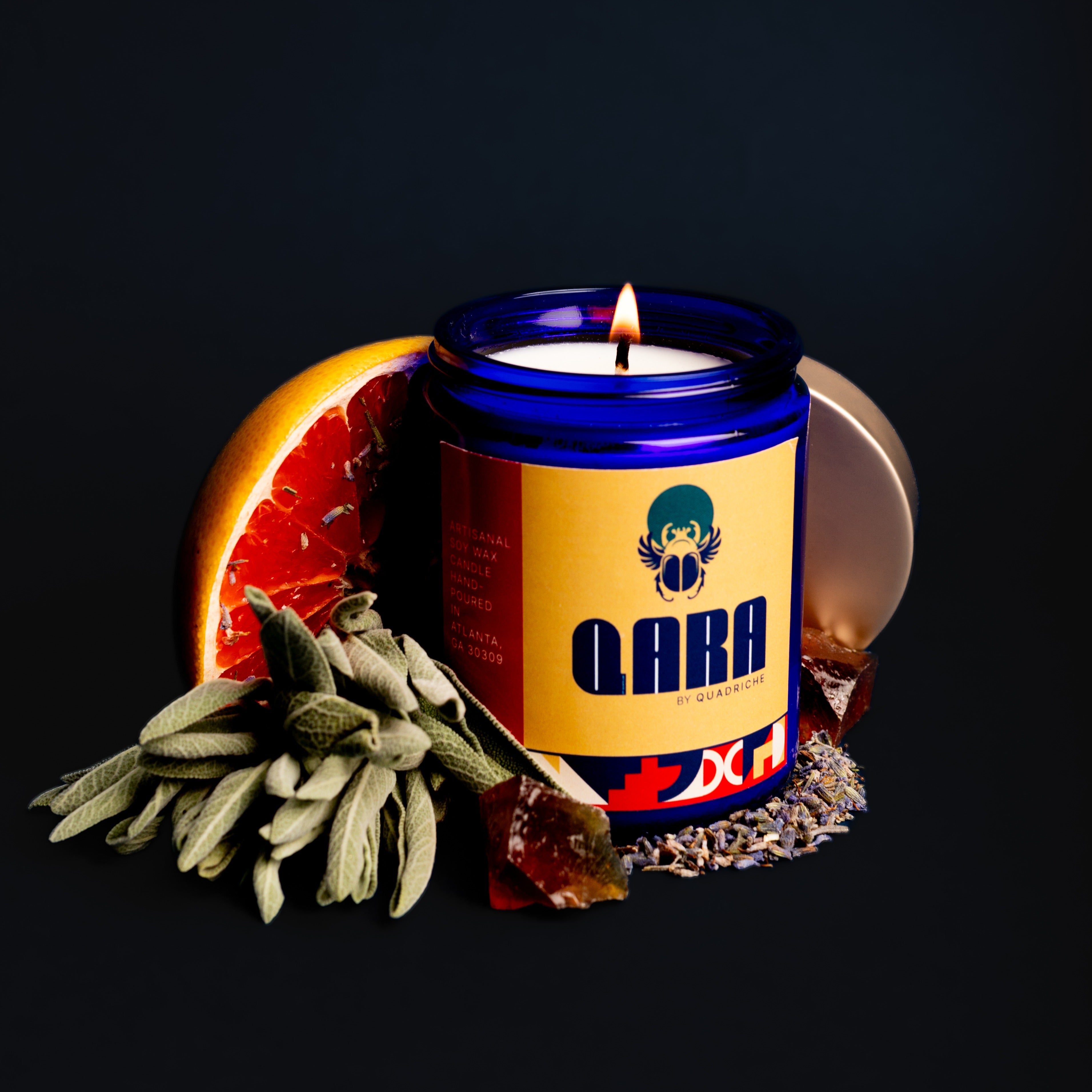 Lit Māori Forest candle with warm amber glow – grapefruit, sage and oakmoss scent in cobalt glass by Quadriche Atlanta