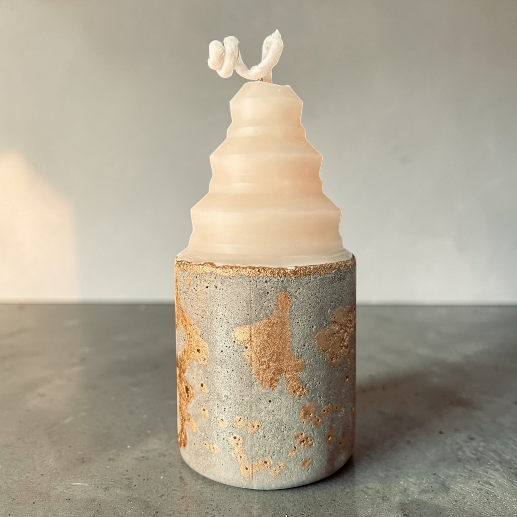 Concrete candle with low rounded shape and textured gold-accented base, mixed media soy wax and concrete candle handcrafted in Atlanta