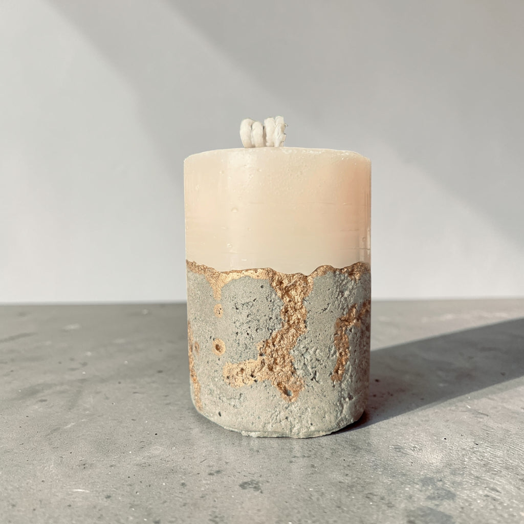 Tall stacked wax concrete candle with textured stone base and gold detailing, modern sculptural home fragrance candle side view made in Atlanta