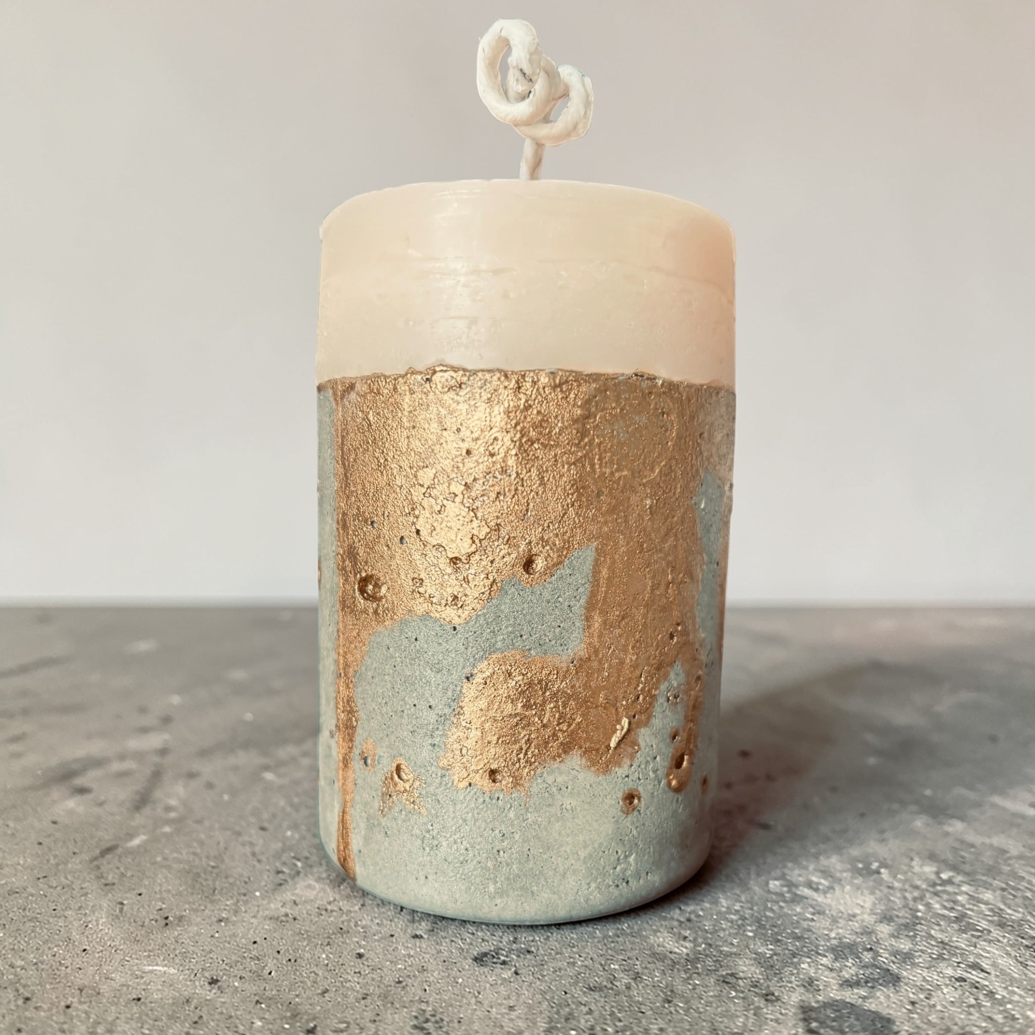 Minimal cylindrical concrete candle with raw textured base and smooth soy wax top, handcrafted modern pillar candle