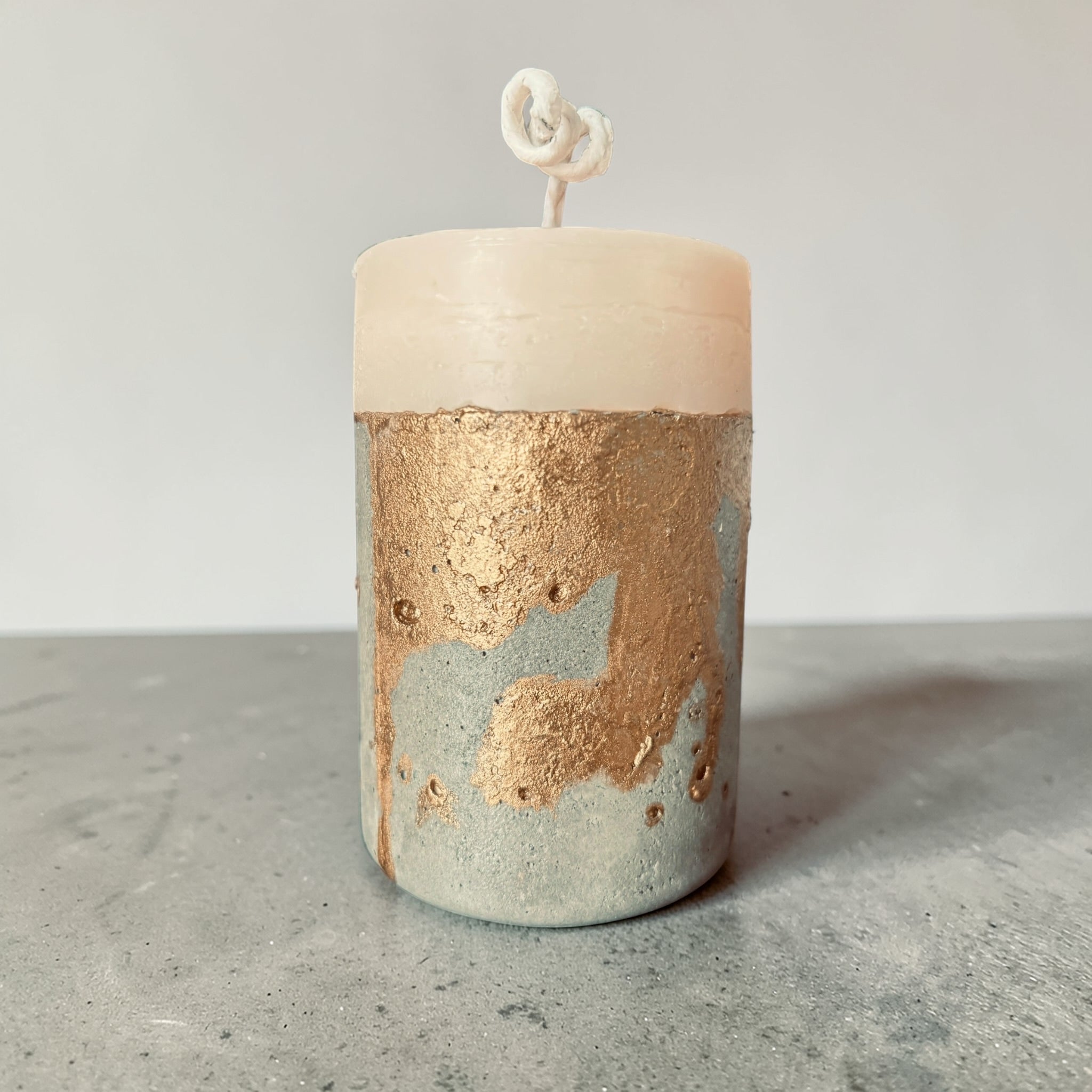 Minimal cylindrical concrete candle with raw textured base and smooth soy wax top, handcrafted modern pillar candle from side