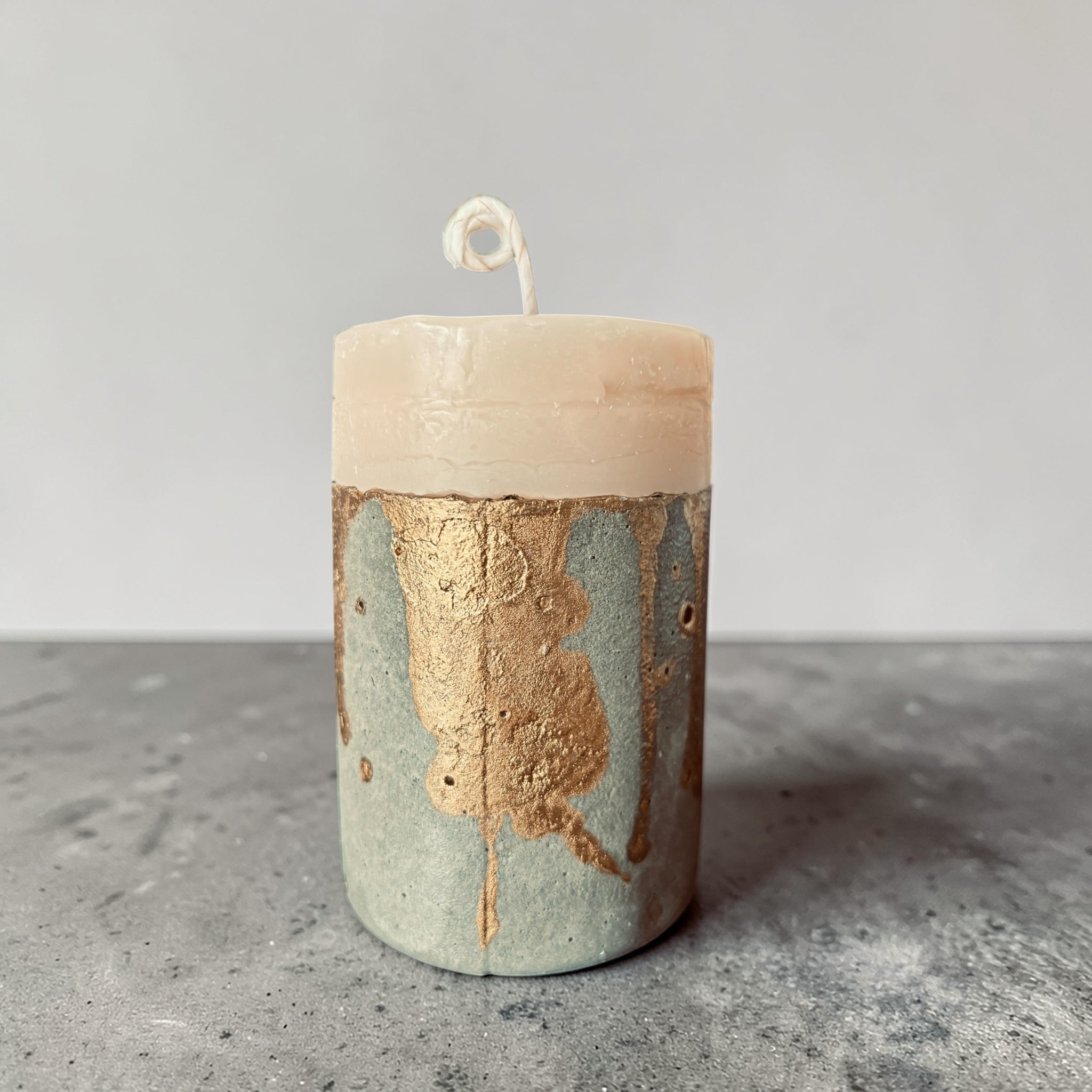 Minimal cylindrical concrete candle with raw textured base and smooth soy wax top, handcrafted modern pillar candle by Quadriche